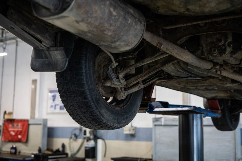 Close-up of checking RV tire pressure on a hot asphalt road with heat haze in the background. practical detail